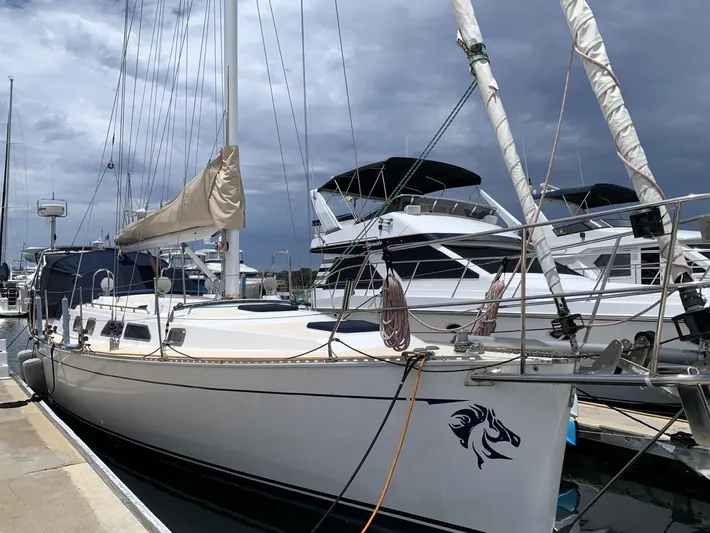 Wild Horses Yacht Photos Pics Sailboat docked at marina, Saga 43 model, 2002, with stormy sky backdrop.