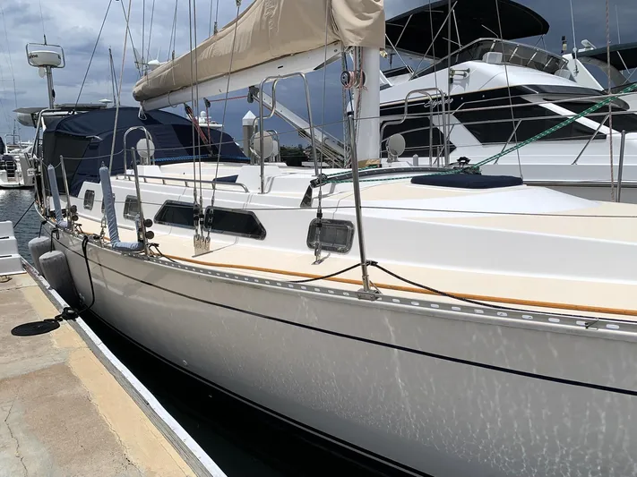 Wild Horses Yacht Photos Pics Sailboat docked at marina, Saga 43 model, 2002, with beige sail cover.