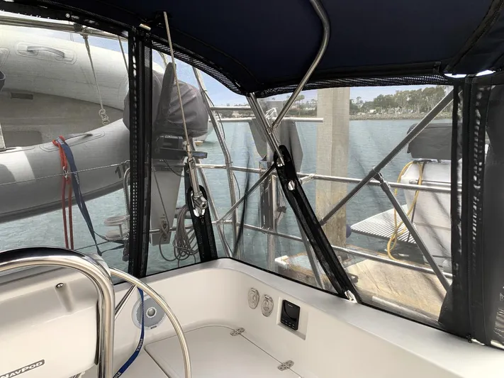 Wild Horses Yacht Photos Pics Cockpit view of 2002 Saga 43 sailboat with protective canopy and marina backdrop.