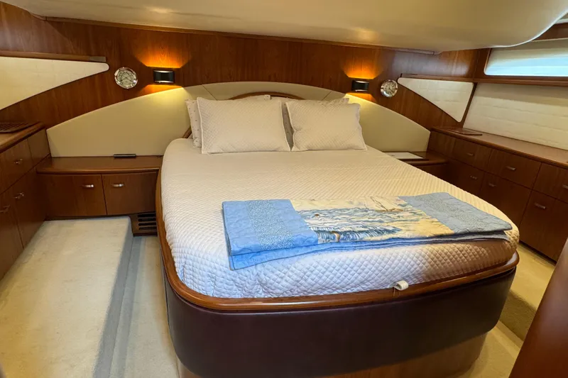  Yacht Photos Pics Luxurious bedroom interior of 2014 Tiara Yachts 5800 Sovran with elegant wood finishes.