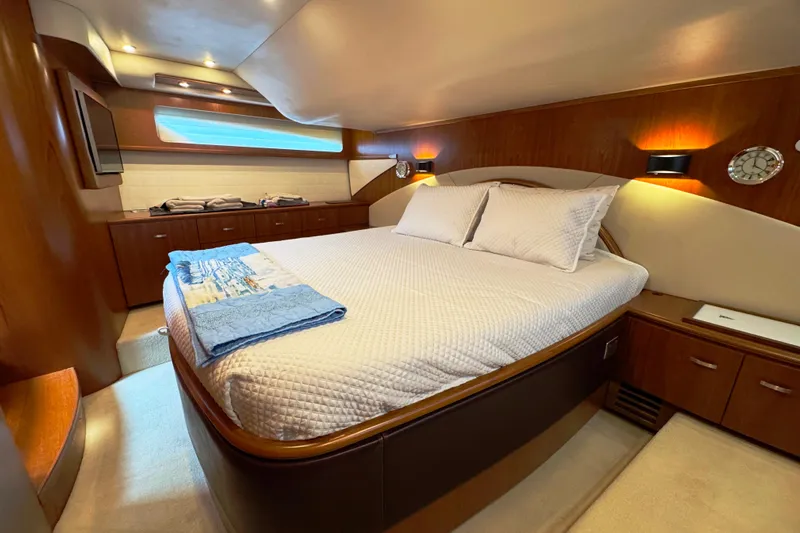  Yacht Photos Pics Luxurious bedroom interior of 2014 Tiara Yachts 5800 Sovran with elegant wood finishes.