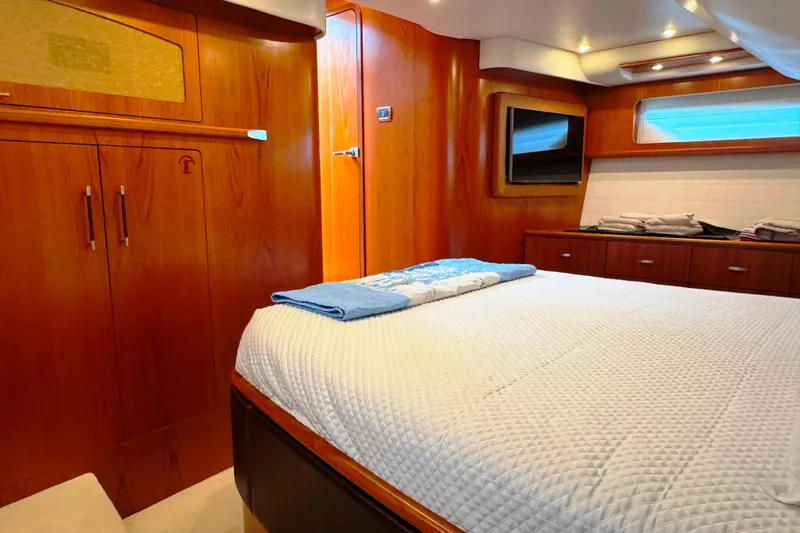  Yacht Photos Pics Luxurious cabin interior of 2014 Tiara Yachts 5800 Sovran with wood finishes and cozy bedding.