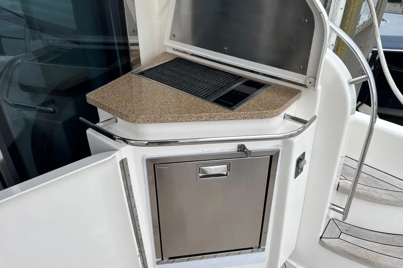  Yacht Photos Pics Outdoor kitchen area on a 2014 Tiara Yachts 5800 Sovran, featuring a grill and storage.