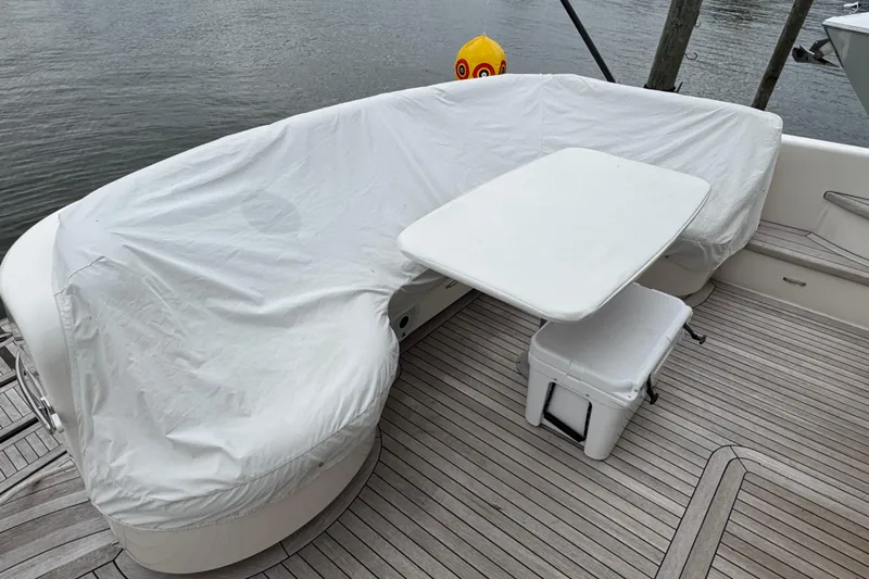  Yacht Photos Pics Covered seating area on 2014 Tiara Yachts 5800 Sovran, featuring a table and cooler.