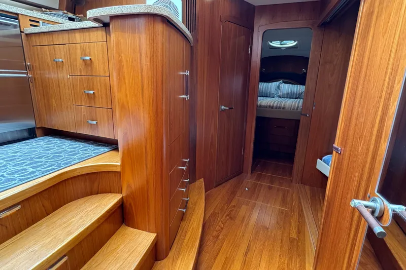 Yacht Photos Pics Luxurious interior of 2014 Tiara Yachts 5800 Sovran with wooden cabinetry and cozy bedroom.