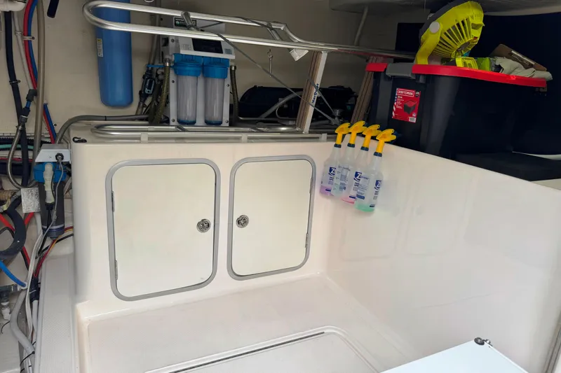  Yacht Photos Pics 2014 Tiara Yachts 5800 Sovran engine room with storage and cleaning supplies.