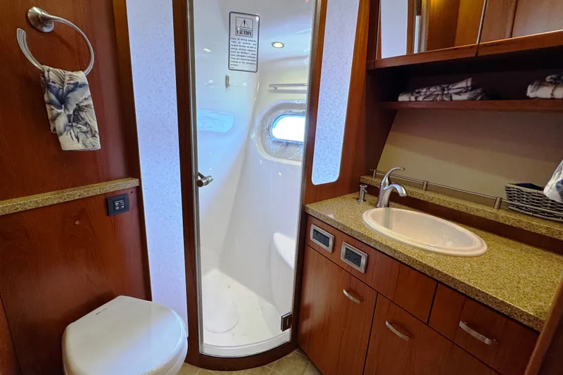  Yacht Photos Pics Luxurious bathroom in 2014 Tiara Yachts 5800 Sovran, featuring modern fixtures and elegant wood cabinetry.