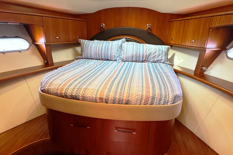 Yacht Photos Pics Luxurious cabin interior of 2014 Tiara Yachts 5800 Sovran with cozy bed and wooden finish.