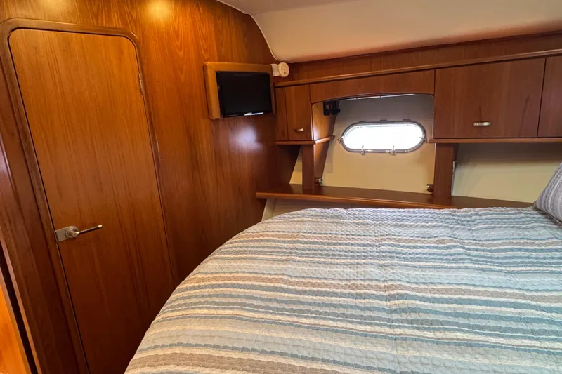  Yacht Photos Pics Cozy cabin interior of 2014 Tiara Yachts 5800 Sovran with wood paneling and bed.