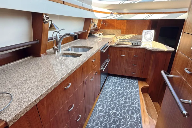  Yacht Photos Pics Luxurious 2014 Tiara Yachts 5800 Sovran kitchen with granite countertops and wooden cabinetry.