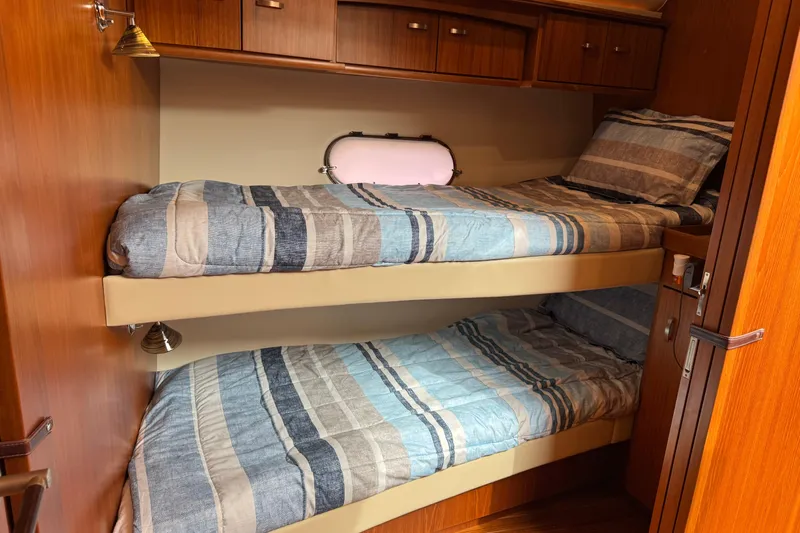  Yacht Photos Pics 2014 Tiara Yachts 5800 Sovran cabin with cozy bunk beds and wooden cabinetry.