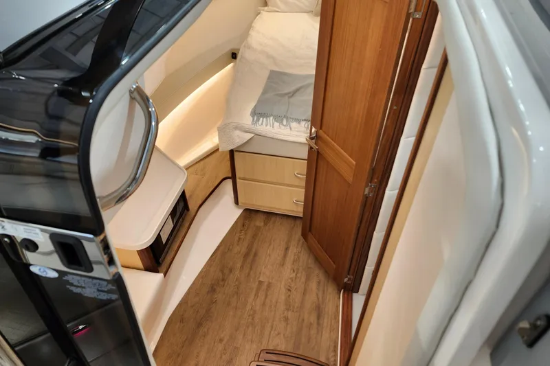  Yacht Photos Pics 2025 Regal 36 XO yacht interior with wood flooring and cozy sleeping area.