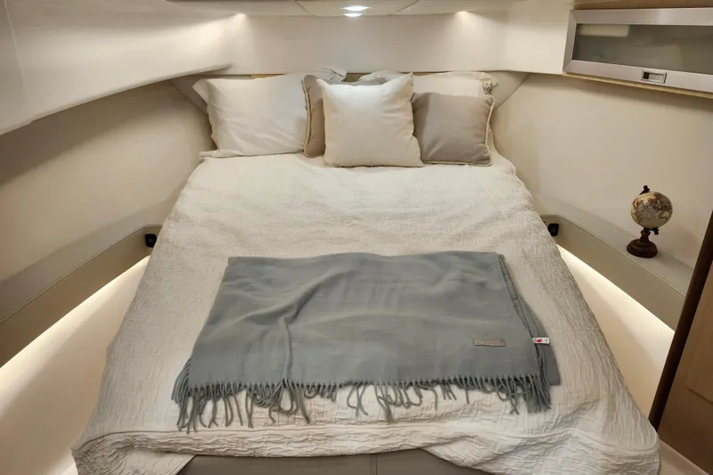  Yacht Photos Pics Cozy cabin interior of 2025 Regal 36 XO yacht with plush bedding and ambient lighting.