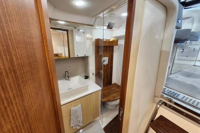  Yacht Photos Pics Luxurious bathroom interior of 2025 Regal 36 XO yacht with modern fixtures and wood accents.