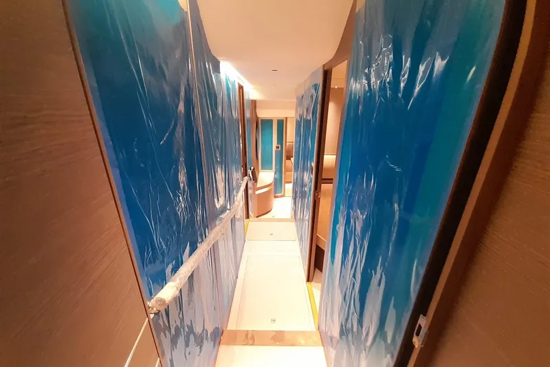  Yacht Photos Pics Narrow hallway inside 2026 Princess Y80 yacht, with protective blue coverings.