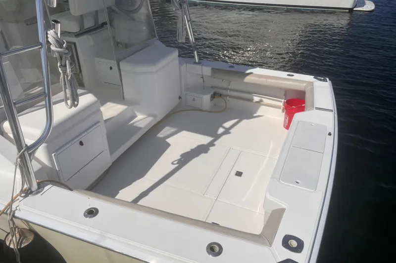 Unreel Yacht Photos Pics 2001 Cabo 31 Express boat deck with seating and storage, docked on calm water.