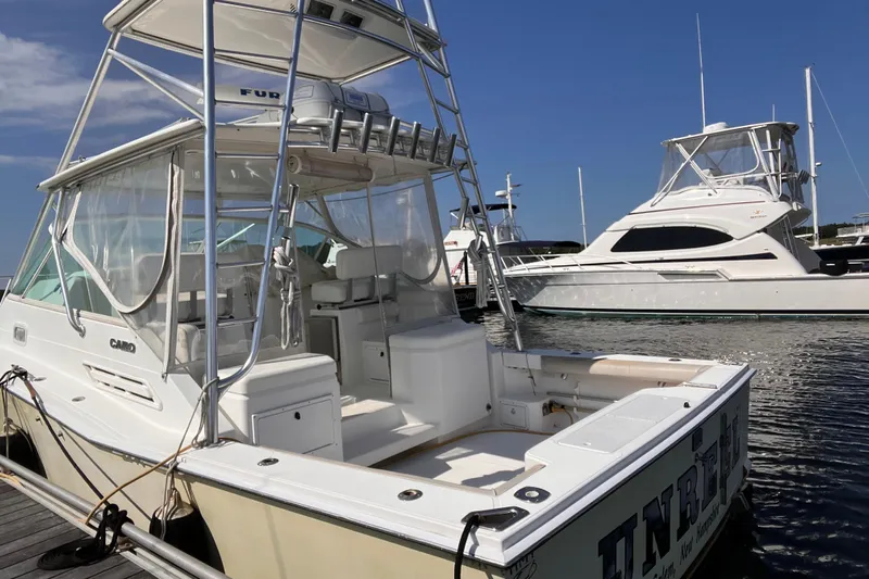 Unreel Yacht Photos Pics 2001 Cabo 31 Express boat docked at marina under clear blue sky.