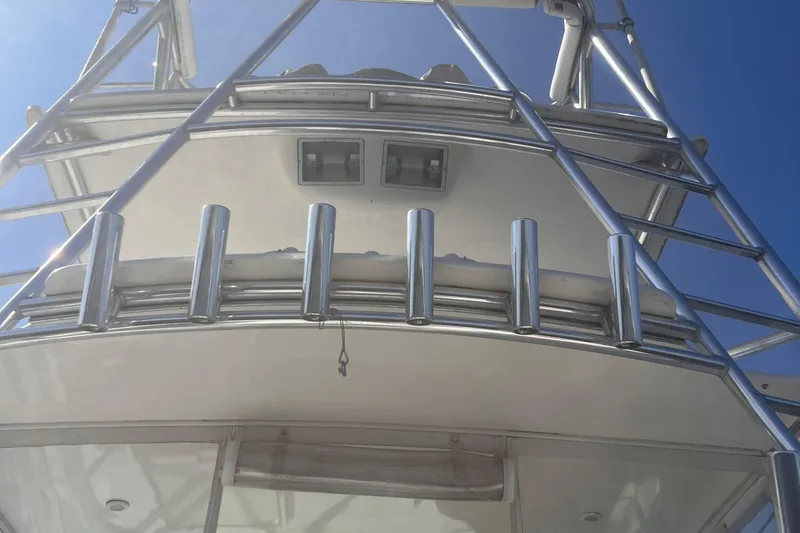 Unreel Yacht Photos Pics 2001 Cabo 31 Express boat tower with rod holders against clear blue sky.