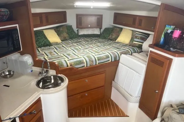 Unreel Yacht Photos Pics 2001 Cabo 31 Express cabin interior with bed, kitchenette, and storage.