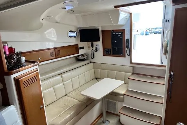 Unreel Yacht Photos Pics 2001 Cabo 31 Express interior with beige seating, table, and electronic equipment.