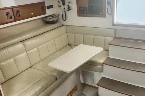 Unreel Yacht Photos Pics 2001 Cabo 31 Express interior with beige leather seating and compact dining table.