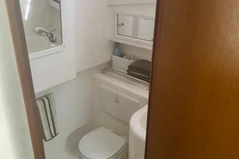 Unreel Yacht Photos Pics 2001 Cabo 31 Express boat bathroom with toilet, sink, and storage shelves.