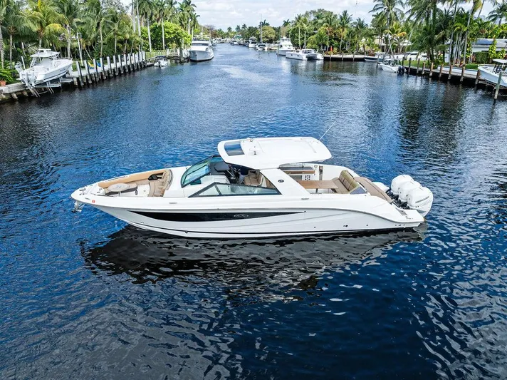  Yacht Photos Pics 2019 Sea Ray SLX 400 OB cruising on a scenic, tree-lined waterway.