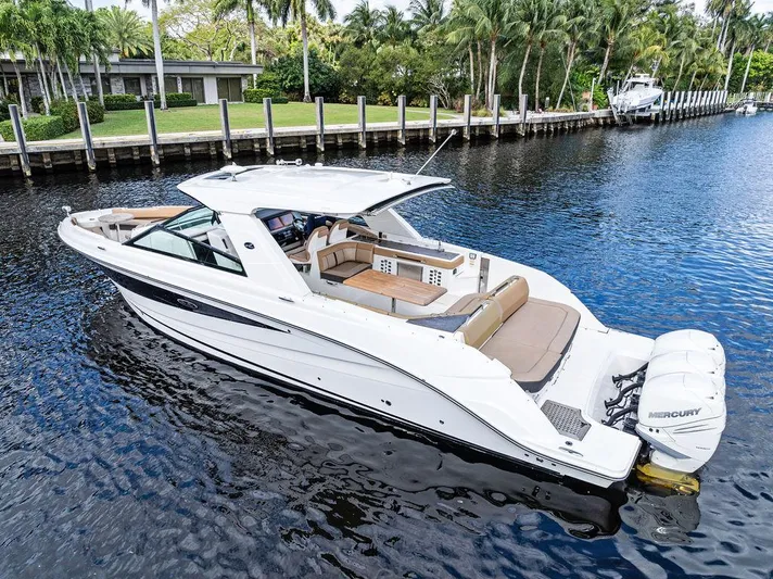  Yacht Photos Pics 2019 Sea Ray SLX 400 OB boat on a calm river, surrounded by lush greenery.
