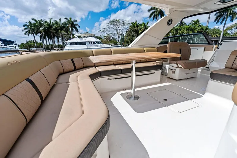  Yacht Photos Pics 2019 Sea Ray SLX 400 OB boat interior with luxurious seating and table, docked near palm trees.