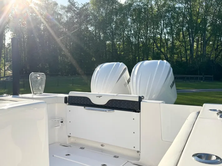  Yacht Photos Pics 2024 Tidewater 292 CC Adventure boat with dual engines, sunlit deck, and forest backdrop.