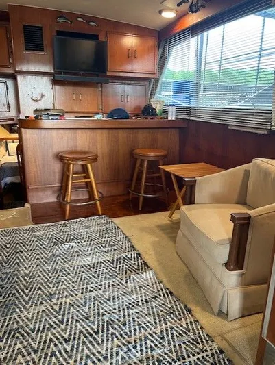 Yacht Photos Pics Interior of 1984 Post 43 Sport Fisherman with wood cabinetry, bar stools, and patterned rug.