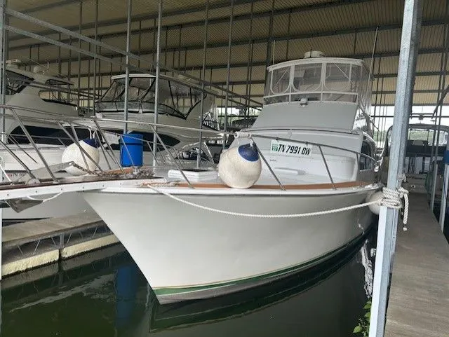 1984 Post 43 Sport Fisherman boat docked in covered marina.