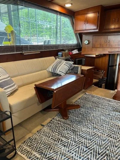  Yacht Photos Pics Interior of 1984 Post 43 Sport Fisherman with sofa, table, and kitchen area.