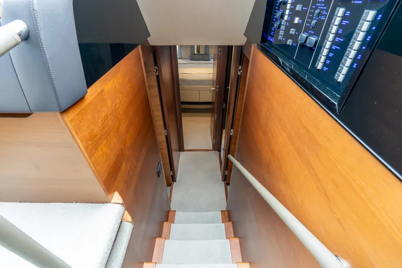 Mamu Yacht Photos Pics Staircase inside 2018 Princess F-68 yacht with wooden paneling and control panel.