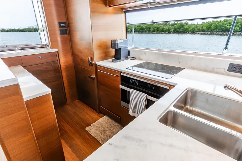 Mamu Yacht Photos Pics Luxurious kitchen interior of 2018 Princess F-68 yacht with modern appliances and wood finish.