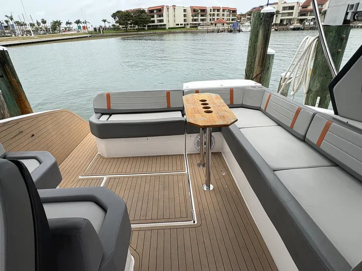  Yacht Photos Pics Luxurious 2023 Hanover 377 yacht deck with elegant seating and wooden table by the marina.
