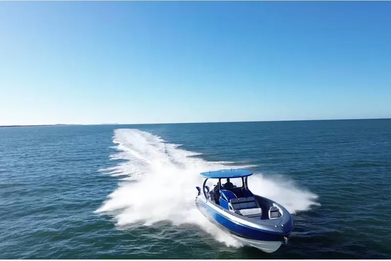 Take It To The Max Yacht Photos Pics 2023 Mystic Powerboats M3800 speeding on open water under clear blue skies.