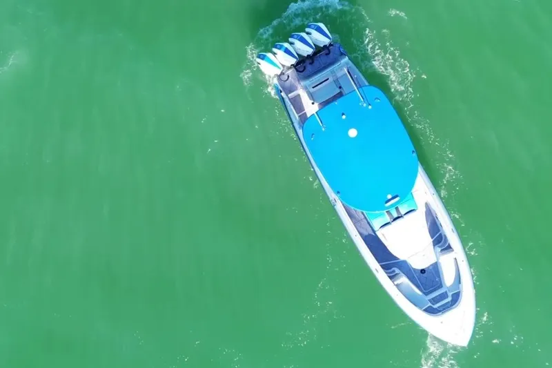 Take It To The Max Yacht Photos Pics Aerial view of 2023 Mystic Powerboats M3800 cruising on green water.