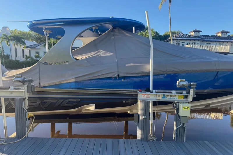 Take It To The Max Yacht Photos Pics 2023 Mystic Powerboats M3800 covered on a dock with hoist system.