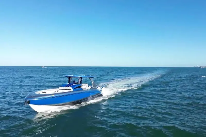 Take It To The Max Yacht Photos Pics 2023 Mystic Powerboats M3800 cruising on open blue ocean under clear sky.