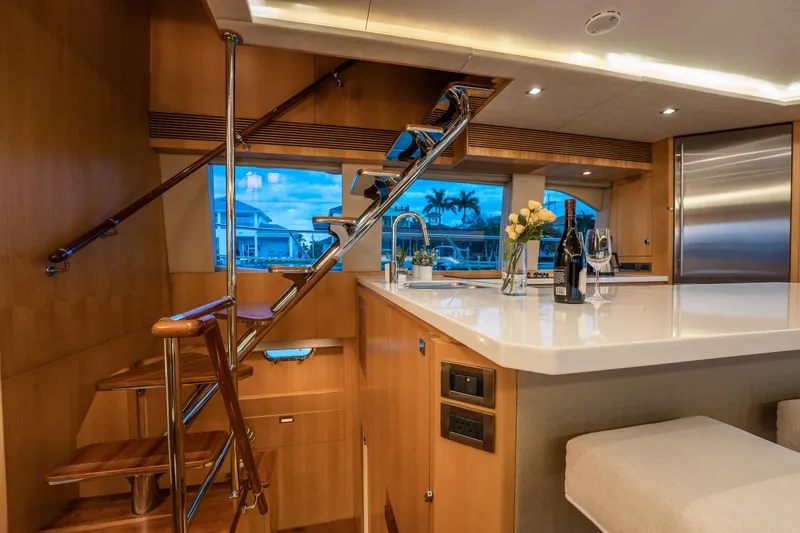 Tranquility Yacht Photos Pics Luxurious interior of 2013 Horizon PC60 yacht with modern kitchen and elegant staircase.