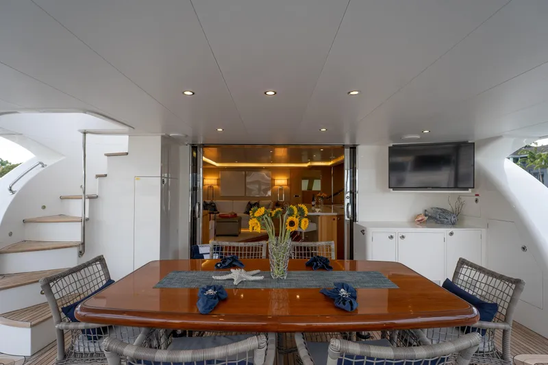 Tranquility Yacht Photos Pics Luxurious Horizon PC60 yacht deck with dining table, sunflowers, and modern interior, 2013 model.