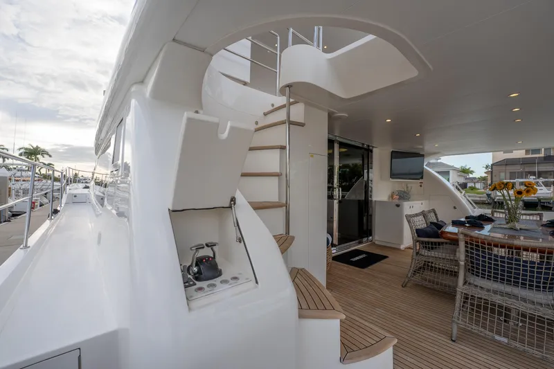 Tranquility Yacht Photos Pics Luxurious 2013 Horizon PC60 yacht deck with spiral staircase and outdoor dining area.