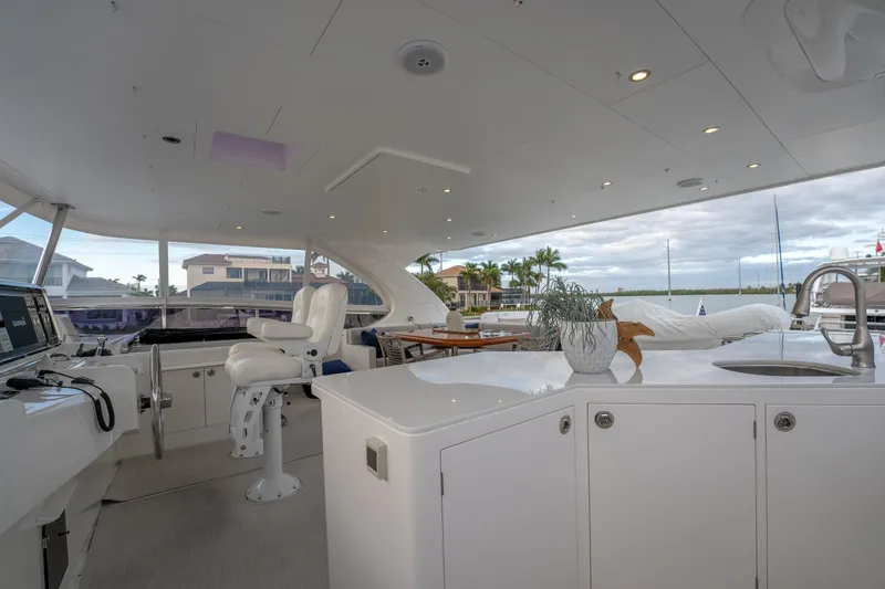 Tranquility Yacht Photos Pics Luxurious 2013 Horizon PC60 yacht interior with helm, seating, and scenic marina view.