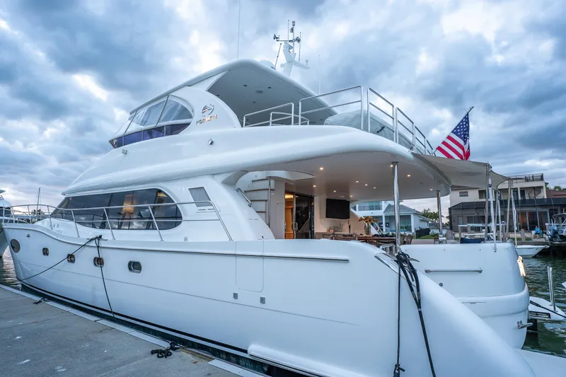Tranquility Yacht Photos Pics Luxurious 2013 Horizon PC60 yacht docked, featuring sleek design and American flag.