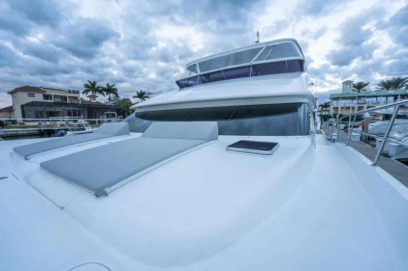 Tranquility Yacht Photos Pics Luxury Horizon PC60 yacht docked, showcasing sleek design and spacious deck under cloudy skies.