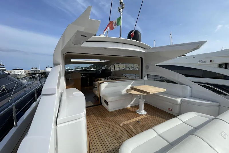  Yacht Photos Pics Luxurious 2013 Pershing 62 yacht with elegant deck seating and table, docked at marina.