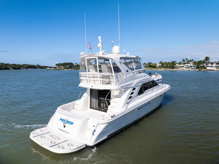  Yacht Photos Pics 2003 Sea Ray 560 Sedan Bridge yacht cruising on a calm waterway.