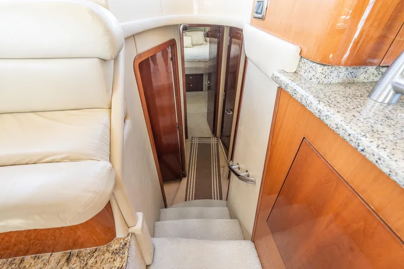  Yacht Photos Pics Interior stairs of 2003 Sea Ray 560 Sedan Bridge yacht, featuring wood and granite finishes.
