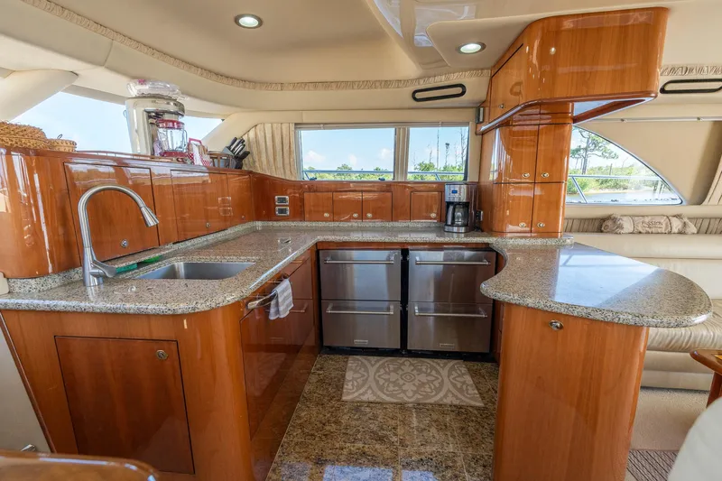  Yacht Photos Pics Luxurious kitchen interior of 2003 Sea Ray 560 Sedan Bridge yacht with wood cabinetry and granite countertops.